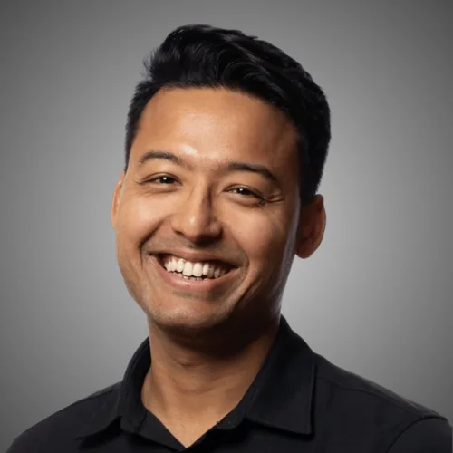 Ankur smiling against a grey backdrop
